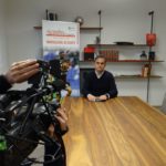Interno di saletta riunione Azeta con operatore video che riprende Ubaldo Torricelli